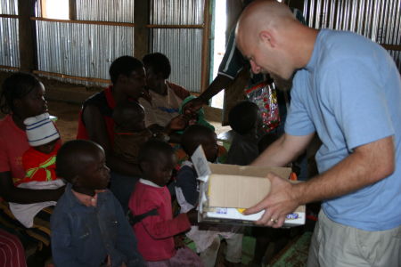 Paul serving cookies to children in Kabarak